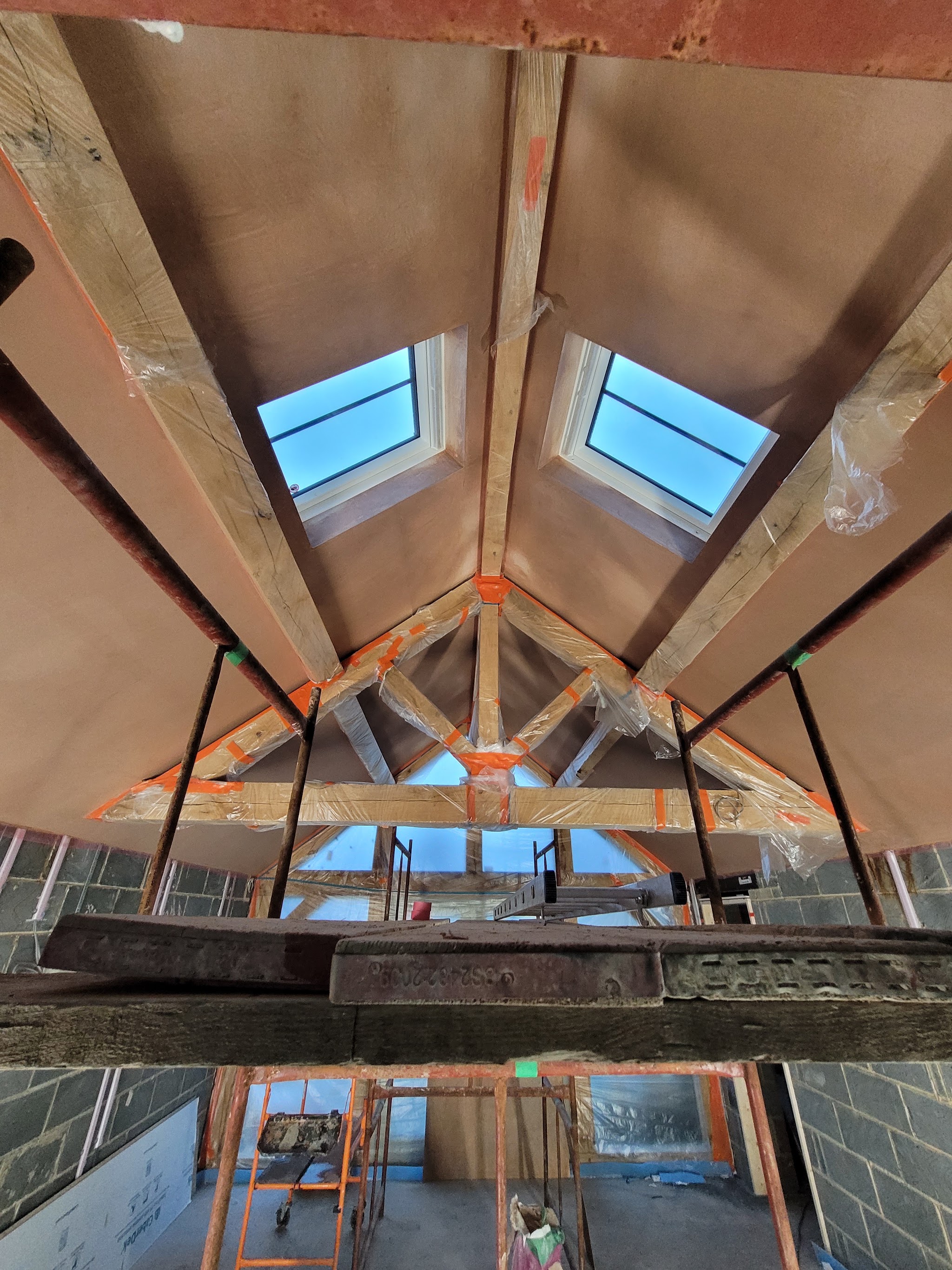 Vaulted ceiling with two roof windows, freshly skimmed between the timber trusses